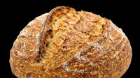 Artisan sourdough bread loaf with crusty golden-brown exterior and flour dusting, isolated on transparent background. Ready for bakery designs, food packaging, menus, print-on-demand products, and culinary graphics.