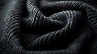 Close-up macro shot of dark knitted wool texture with soft shadows and ribbed pattern, perfect for fashion, textile design and winter season backgrounds.