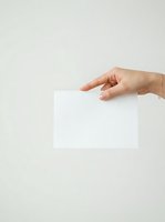 Hand holding blank white card or paper against neutral background, suitable for business branding, marketing mockups, and promotional material design.