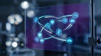 Futuristic digital network visualization on monitor screen with glowing hexagonal nodes and connecting lines in purple and blue tones for tech presentations.