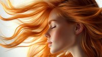 Young Caucasian woman with flowing golden orange hair in motion, eyes closed in peaceful expression, soft warm lighting creates dreamy atmosphere for beauty concepts.