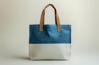 Blue and white canvas tote bag with tan leather handles, isolated on white background. Suitable for fashion, retail, e-commerce, product mockups, and lifestyle design projects.