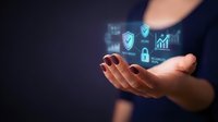 Businesswoman holding glowing digital security icons including shield, lock, and growth chart symbols representing data protection and cybersecurity solutions for enterprise networks.