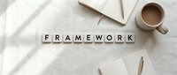 Wooden letter blocks spelling FRAMEWORK on white fabric surface with coffee cup, notebooks and pencils for business planning and strategy development.