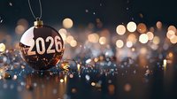 Festive Christmas ball ornament with 2026 number against blurred bokeh lights background creating magical holiday atmosphere.