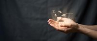 Young adult with medium skin tone holding glowing digital data particles and light effects in open palm against dark background, representing technology, innovation, and digital transformation concepts.