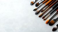 Various professional art brushes arranged on white textured background with copy space for creative design projects.