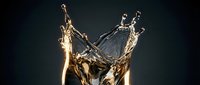 Liquid gold splash frozen in motion against dark background, suitable for luxury beverage, cosmetics, and premium product advertising campaigns.