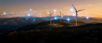 Wind turbines on mountain ridge at sunset with digital network connections overlay representing renewable energy technology and smart grid infrastructure.