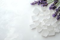 Fresh lavender sprigs with scattered ice cubes on white textured background, creating minimalist spa and wellness composition with copy space.