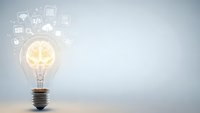 Glowing light bulb with brain inside surrounded by floating technology icons on clean background for innovation and creativity concepts.