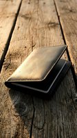Brown leather wallet on rustic wooden table surface with natural lighting and shallow depth of field for financial and lifestyle concepts.