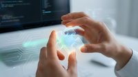 Hands holding glowing digital hologram with circuit patterns above laptop displaying code for futuristic technology and innovation concepts.