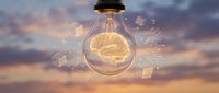 Glowing brain inside light bulb with floating geometric shapes against sunset sky, representing innovation, creativity, and intelligent ideas for business and technology concepts.