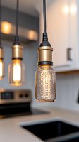 Modern pendant light with textured glass jar and vintage Edison bulb illuminating kitchen counter space, creating warm ambient glow against blurred background.
