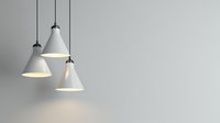 Modern white pendant lamps hanging from ceiling against gray wall, illuminated with warm light creating minimalist contemporary interior design atmosphere.