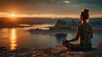 Young woman practicing yoga meditation at sunset overlooking ocean coastline. Peaceful mindfulness moment during golden hour for wellness and relaxation content.