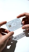 Close-up of hands holding a translucent payment card with contactless technology against white background. Suitable for financial services, banking, and digital payment marketing materials.