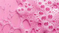 Pink soap foam with bubbles and suds creating abstract macro texture background with soft dreamy effect, suitable for cosmetic and beauty industry designs.