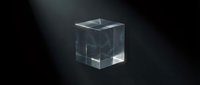 Transparent glass cube with light refraction on dark background, suitable for technology, science, and abstract design projects.