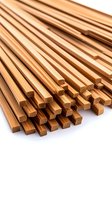 Stack of wooden chopsticks on white background showing natural bamboo texture and grain pattern, arranged in diagonal composition for restaurant and dining concepts.