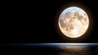 Bright full moon rising over calm ocean horizon at night with glowing reflection on dark water surface creating mystical atmosphere.