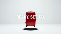 Red hardshell carry-on suitcase with bold Ready Set Go text on white background, travel motivation concept for adventure and vacation campaigns.
