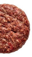 Raw ground beef meat ball with visible fat and texture, isolated on white background for food preparation, cooking, and culinary design projects.