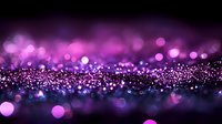 Magical purple glitter background with bokeh effect and sparkles scattered on dark surface creating dreamy atmosphere for festive designs and celebrations.