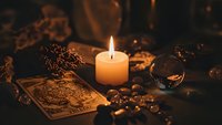 Mystical tarot cards with burning candle and crystal ball creating atmospheric fortune telling scene with warm candlelight for spiritual guidance and divination.