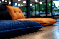 Modern lounge area with navy blue and orange cushions on wooden floor, soft focus bokeh lights creating cozy atmosphere for interior design and hospitality settings.