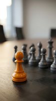 Orange wooden pawn in focus with blurred black chess pieces behind on dark table. Leadership, strategy, and business concepts for corporate presentations and marketing materials.