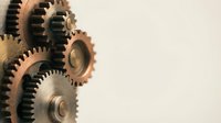 Vintage brass mechanical gears and cogs machinery parts on neutral background for industrial engineering and steampunk design projects.