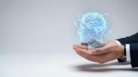 Businessman hands holding glowing holographic brain with neural network connections representing artificial intelligence and machine learning technology.