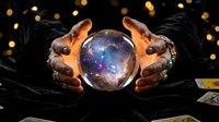 Mystical fortune teller hands holding glowing crystal ball with cosmic galaxy inside for spiritual guidance and divination practices on dark background.