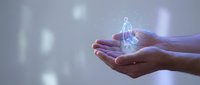 Hands holding glowing lightbulb with digital network connections representing innovation, creativity and bright ideas for business technology solutions.