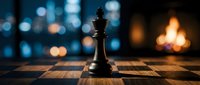 Black chess king piece standing on wooden chessboard with blurred city lights and warm fireplace creating atmospheric bokeh background for strategic planning.