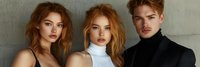 Young fashion models with red hair posing together in studio setting against textured wall, dramatic lighting creates moody atmosphere for editorial style shoot.