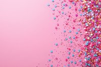 Colorful star-shaped sprinkles and confetti scattered on pink background creating festive border design, copy space for party and celebration layouts.