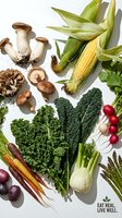 Fresh organic vegetables and mushrooms arranged on white background including corn, kale, radishes, carrots and fungi for healthy cooking and nutrition.