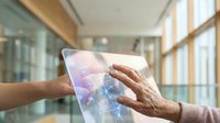 Senior woman using digital tablet with holographic interface in modern office building for technology and innovation concepts.
