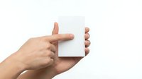 Hands holding blank white card mockup for branding, business card design, greeting card template, or promotional material presentation.