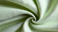 Soft green fabric with elegant swirl pattern creating luxurious textile background for fashion design projects and interior decoration concepts.