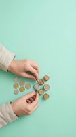 Caucasian hands arranging copper coins on mint green background, representing financial planning, savings, and money management for business and personal finance concepts.