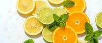 Sliced citrus fruits including lemons, limes and oranges arranged with fresh mint leaves on white background for food and beverage design.