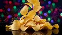 Golden potato chips falling and stacking with colorful bokeh lights background for party snacks and celebration food concepts.