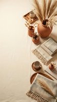 Cozy autumn home decor flat lay with pampas grass, ceramic pottery, woven textiles and warm earth tones creating peaceful hygge atmosphere for interior design.