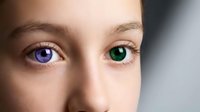 Close-up portrait of young woman with striking heterochromia featuring one blue eye and one green eye showcasing rare genetic condition and natural diversity.