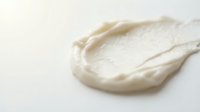 Creamy white cosmetic product smear or skincare lotion texture on isolated background, suitable for beauty and wellness design projects.
