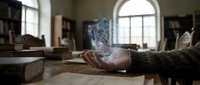 Holographic shield icon floating above open palm in vintage library setting with books and arched windows creating futuristic cybersecurity concept.